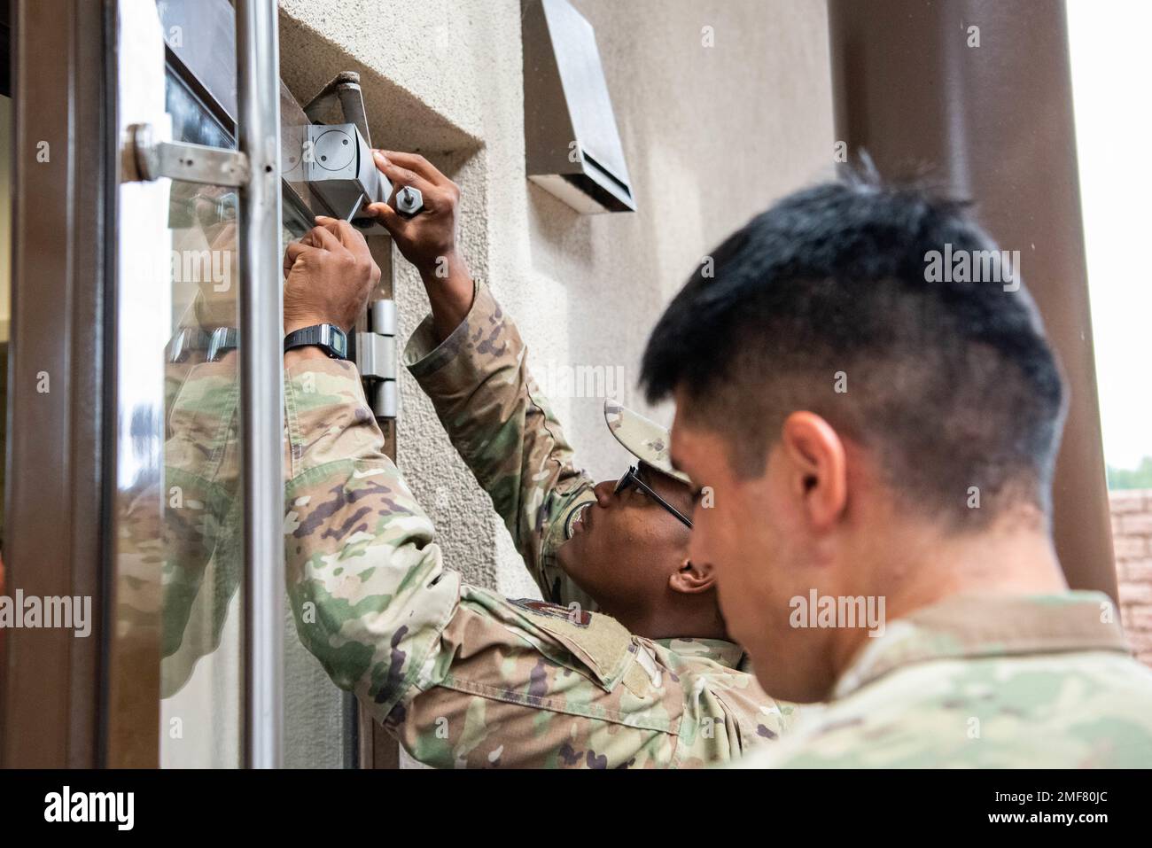 BASE AEREA DI RAMSTEIN, GERMANIA – STATI UNITI Air Force Airman 1st Class Tayvien Walker, 786th l'ingegnere civile Squadron locksmith regola un chiudiporta alla base aerea di Ramstein, Germania, 17 agosto 2022. Oltre a risolvere i problemi di bloccaggio, i fabbri regolano anche le portiere per garantire che i sistemi di bloccaggio funzionino in modo efficace. Foto Stock