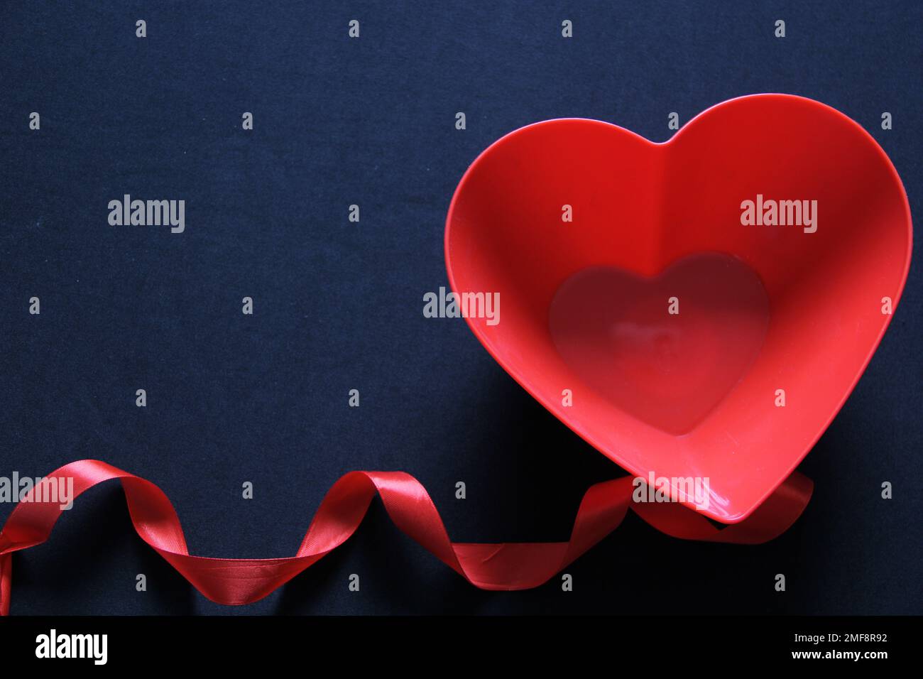 Scatola di cioccolatini cuori rossi e rosa su sfondo nero con nastro rosso,  San Valentino, banner pubblicitario Foto stock - Alamy