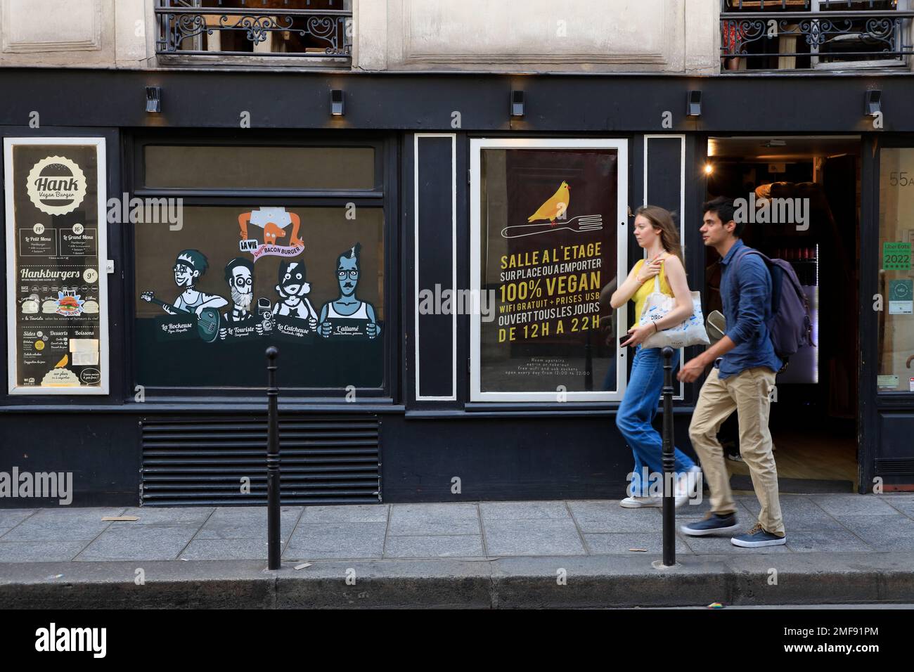 Gente che cammina accanto all'Hank Burger vegan, un ristorante vegetariano di hamburger a Marais. Parigi. Francia Foto Stock