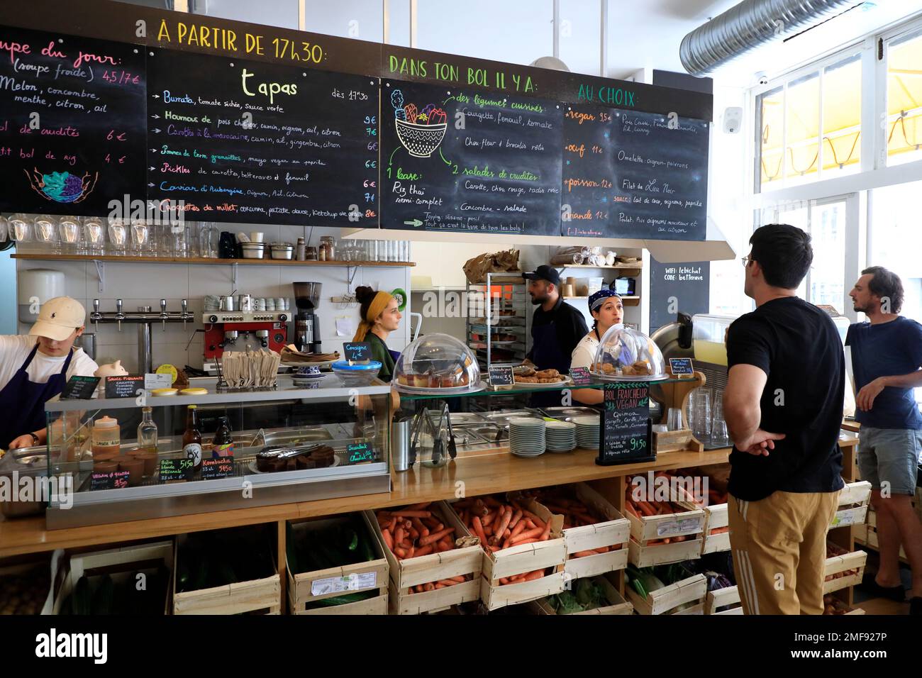 I clienti ordinano i pasti all'interno di le Bichat, un ristorante ecologico e vegetariano che serve cibi biologici e da fattoria a tavola e bevande nel 10th° arrondissement di Paris.France Foto Stock