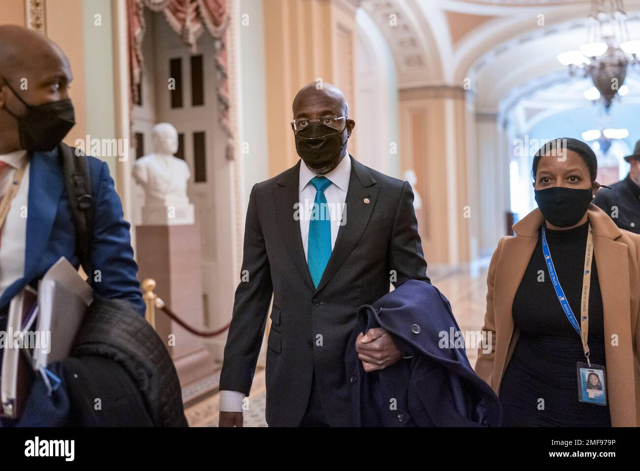 Newly-elected Sen. Raphael Warnock, D-Ga., center, leaves a meeting with other members of the Democratic Caucus on their their first full day in the majority, at the Capitol in Washington, Thursday, Jan. 21, 2021. Warnock, the senior pastor of Ebenezer Baptist Church in Atlanta, unseated Republican Sen. Kelly Loeffler of Georgia. (AP Photo/J. Scott Applewhite) Foto Stock