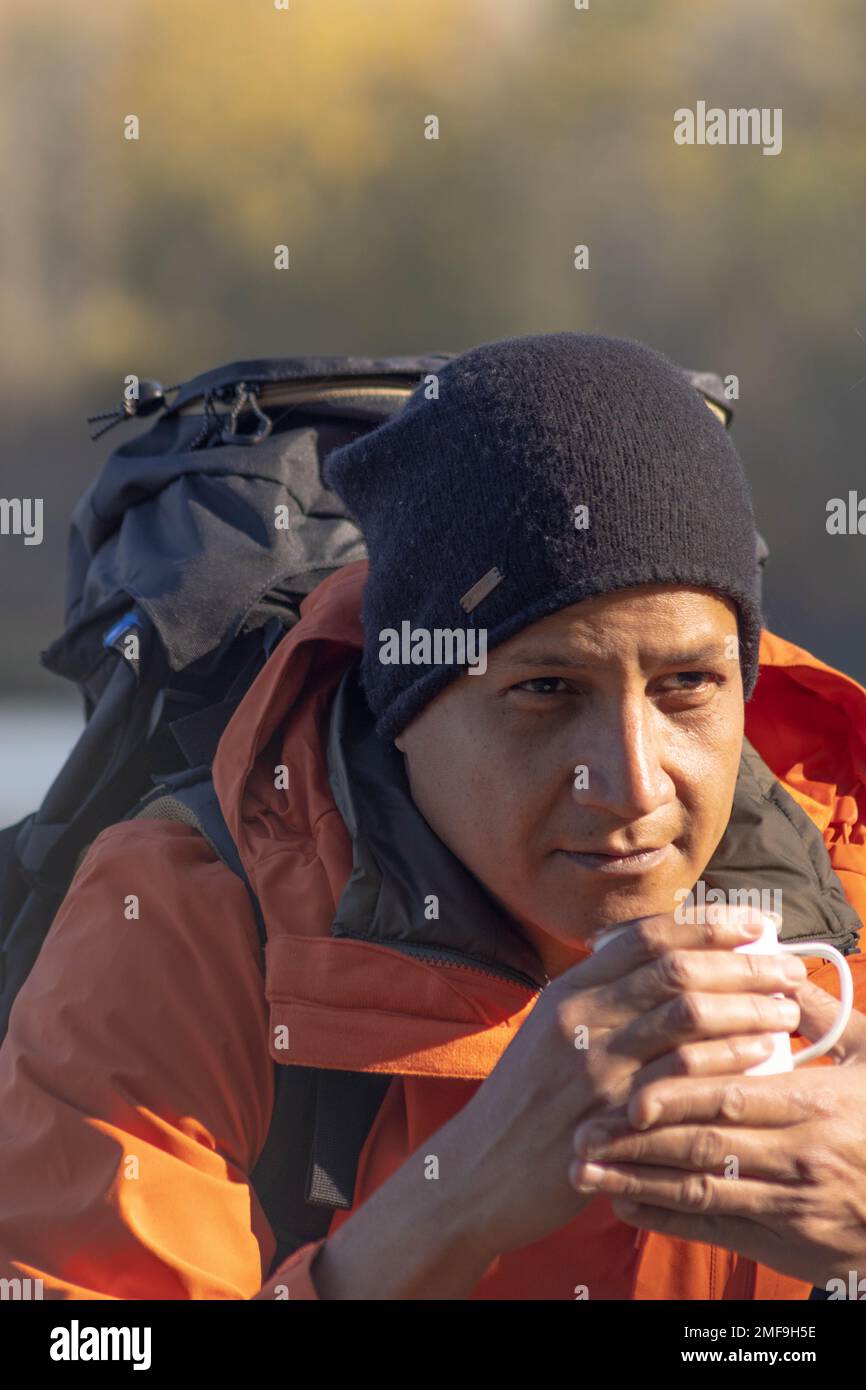 Ritratto di viaggiatore uomo al lago in autunno con una tazza di caffè. Foto di alta qualità Foto Stock
