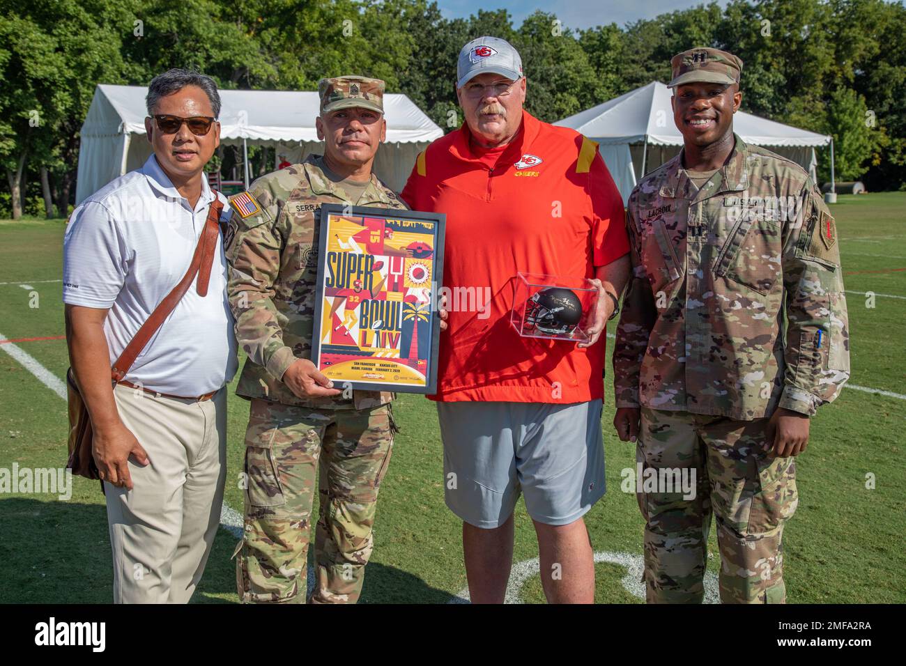 STATI UNITI Comando dell'esercito Sgt. Maggiore Albert Serrano (centro a sinistra), il 1st° Senior Infanty Division Enlisted Advisor - Fort Riley riceve un poster firmato dal capo allenatore dei Kansas City Chiefs Andy Reid e gli regala un casco racchiuso 1st Infanty Division durante il campo di addestramento dei Kansas City Chiefs, 18 agosto 2022, In St. Joseph, Missouri. Il 1st INF. Div Ha collaborato con i Chiefs per ospitare un evento "Meet Your Army" durante il campo di addestramento della squadra Giornata dell'apprezzamento militare, in cui uomini e donne di servizio di ogni ramo militare degli Stati Uniti hanno avuto l'opportunità di incontrare i membri della comunità locale, lo stef della squadra dei Chiefs Foto Stock