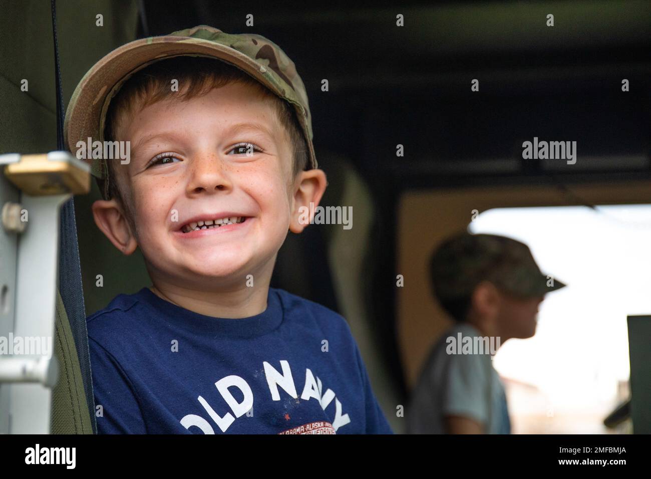 William Curl, figlio di Maj. Matthew Curl, in servizio con gli Stati Uniti Esercito Southern European Task Force, Africa, sorride di gioia durante la Giornata del Leone al lavoro a Caserma del DIN, Vicenza, Italia, 19 agosto 2022. L'evento ha dato ai bambini militari una comprensione di alcuni dei compiti che i loro genitori hanno bisogno di padroneggiare per rimanere pronti per il combattimento Foto Stock