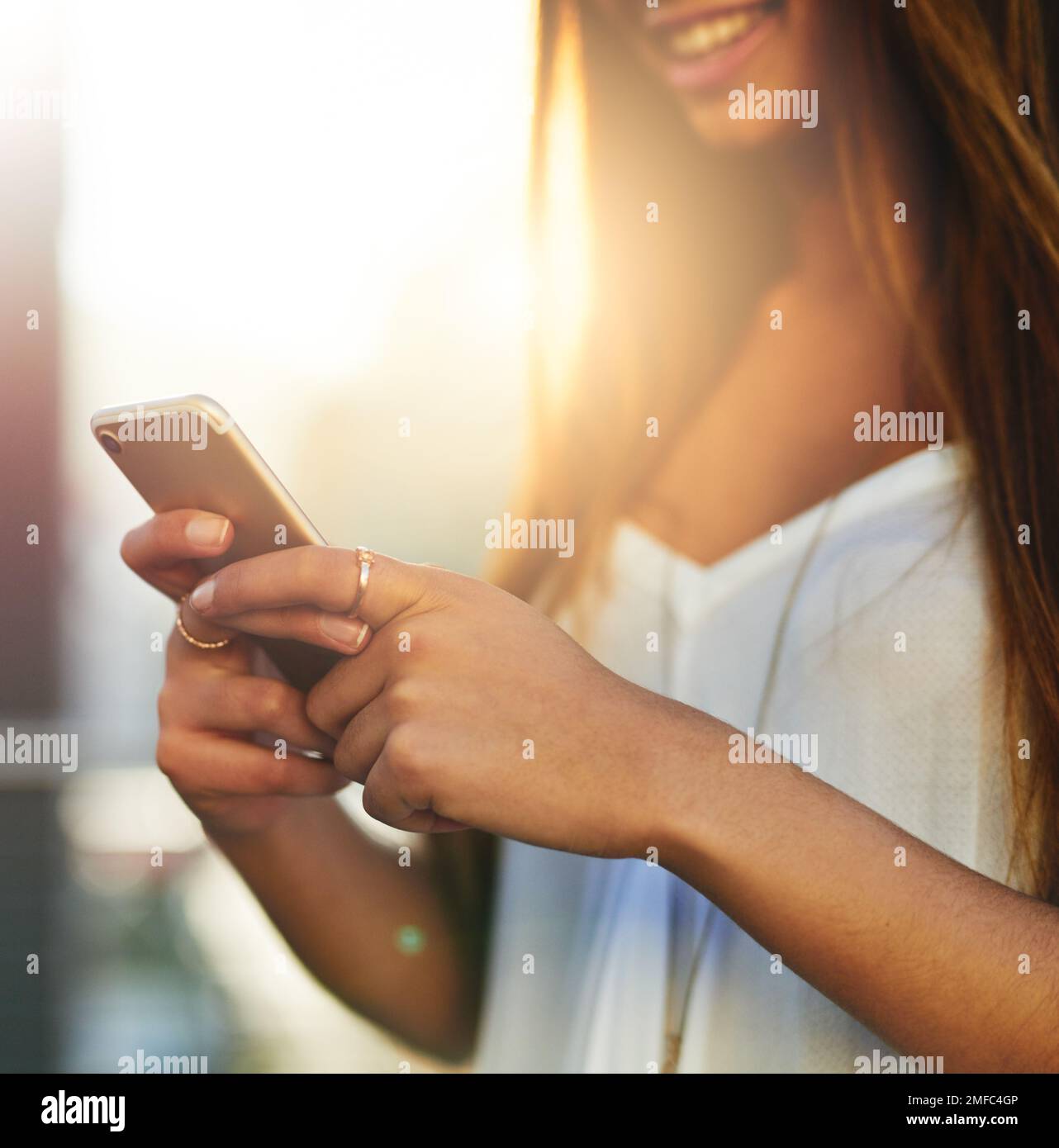 Check in in corso. una giovane donna irriconoscibile che invia un messaggio di testo mentre si è in piedi fuori. Foto Stock