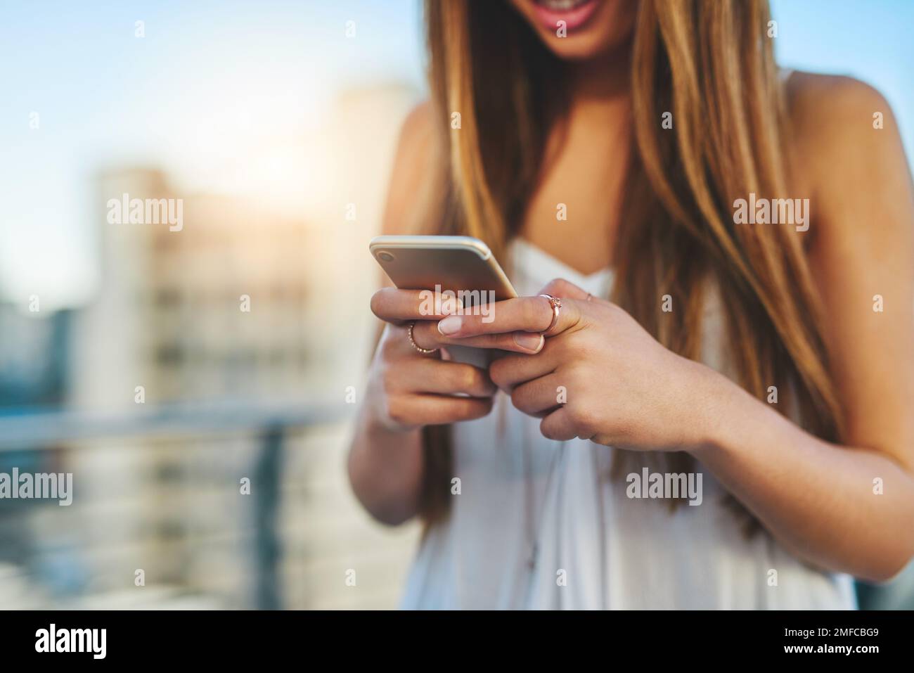 Shes sempre online. una giovane donna irriconoscibile che invia un messaggio di testo mentre si è in piedi fuori. Foto Stock
