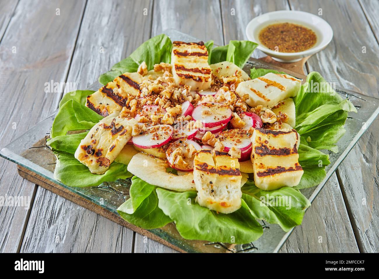 Insalata di mele, lattuga e formaggio halloumi su legno Foto Stock