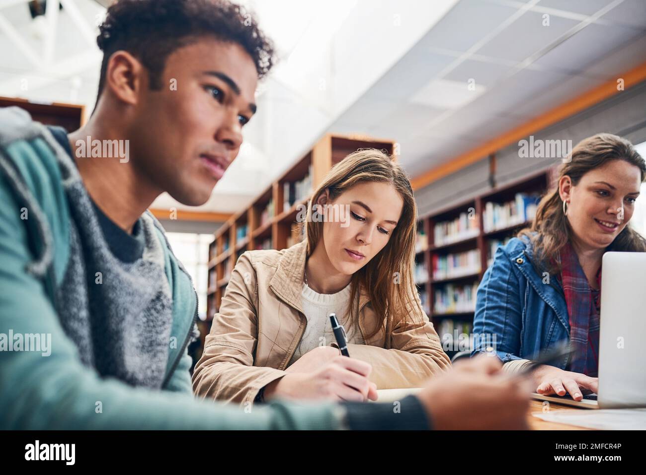 Lavorare sodo per ottenere i voti migliori. un gruppo di studenti che studiano duro in una biblioteca. Foto Stock