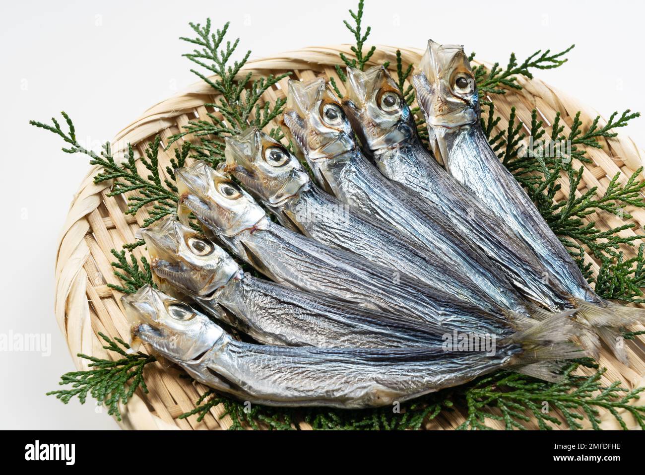 Le sardine di Urume sono servite in un colino posto su uno sfondo bianco. Cibo giapponese, pesce secco. Foto Stock