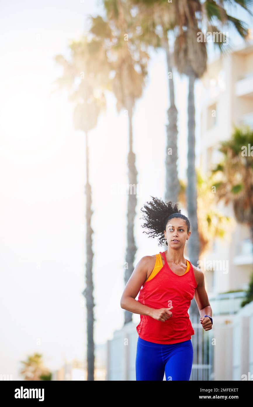 La corsa non si limita solo al sudore. una giovane donna sportiva che corre da sola in città. Foto Stock