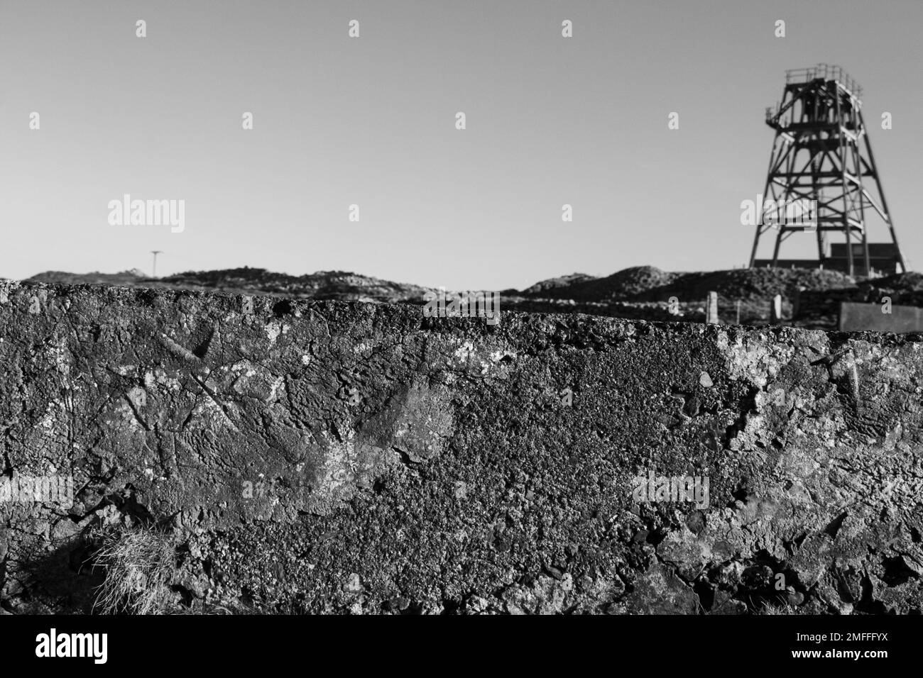 Parete in cemento con attrezzature minerarie sullo sfondo, in bianco e nero, spazio per la copia Foto Stock