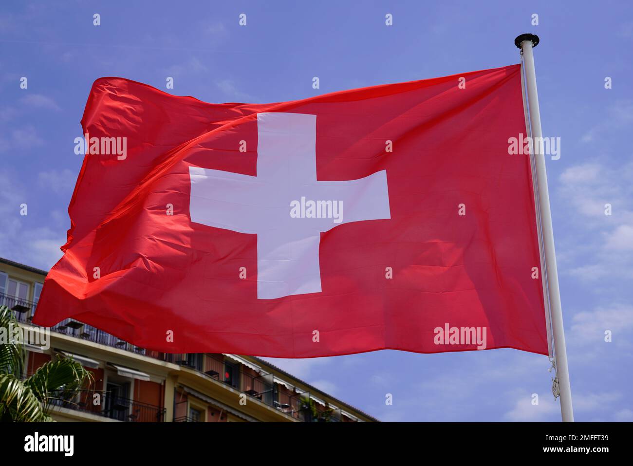 bandiera svizzera italiana galleggiante in stuoia con vento in cielo nuvoloso Foto Stock