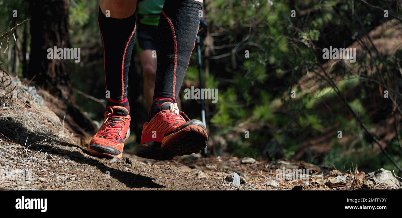 Trail running workout all'aperto su terreni rocciosi, scarpe sportive dettaglio su un impegnativo percorso forestale Foto Stock