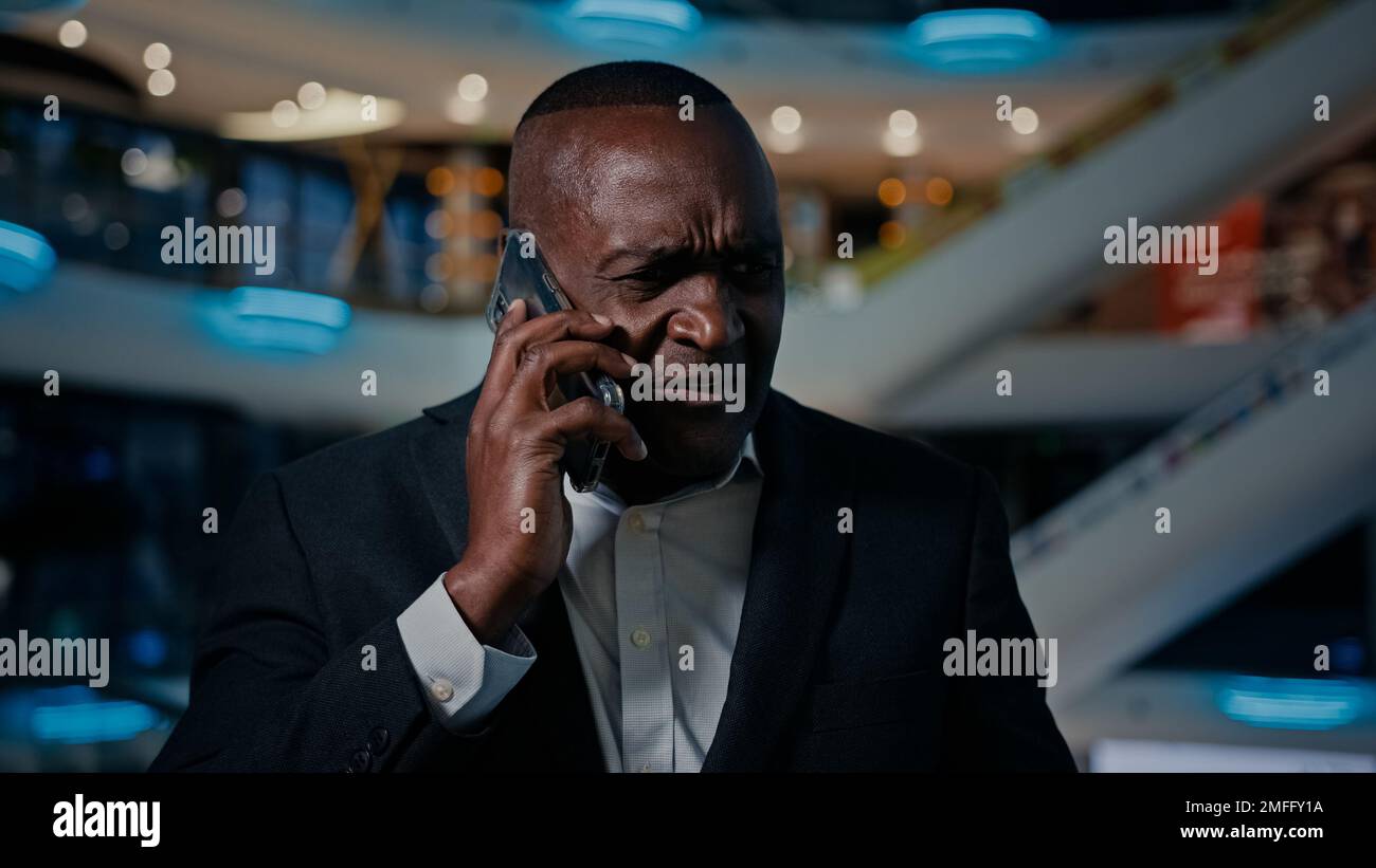 Pensivo anziano etnico uomo esecutivo d'affari pensiero risposta dispiaciuta chiamata cellulare afroamericano arrabbiato parlare telefono cellulare in casa stressato Foto Stock