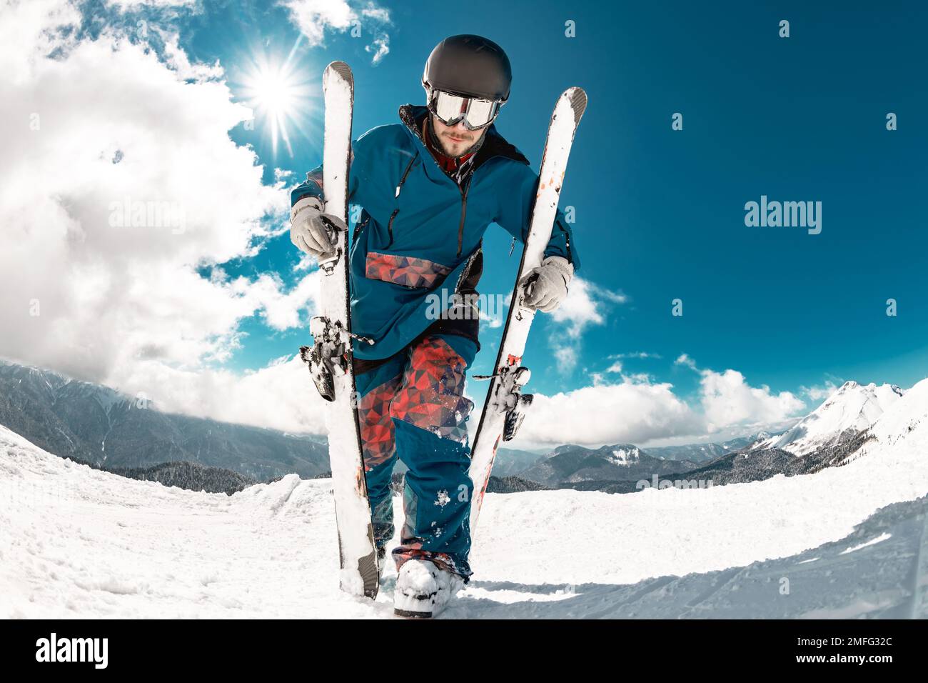 Felici giovani sciatori passeggiate con sci in mano in cima alla montagna. Concetto di stazione sciistica Foto Stock