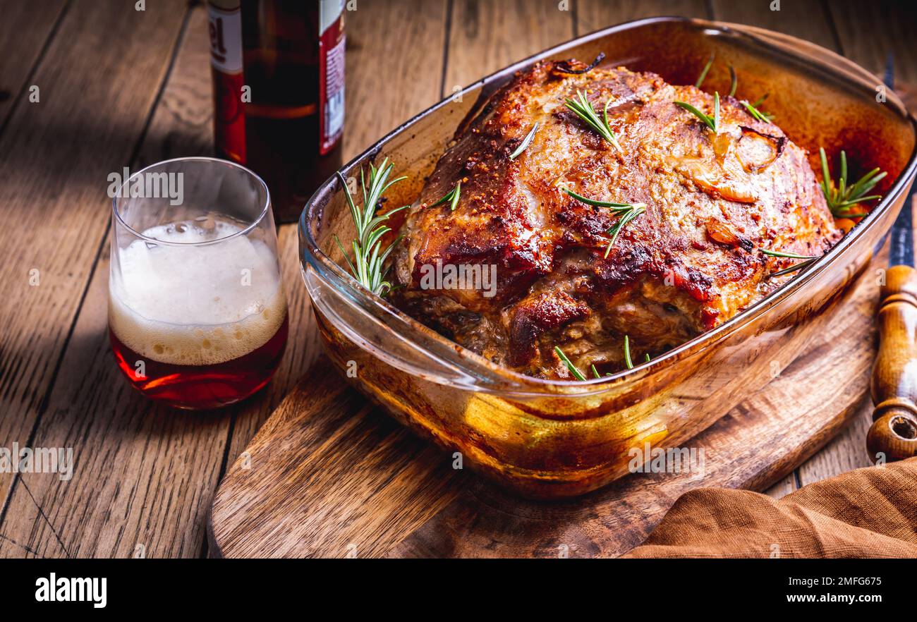 Carne di maiale arrosto con patate, rosmarino e salsa di birra in casseruola Foto Stock