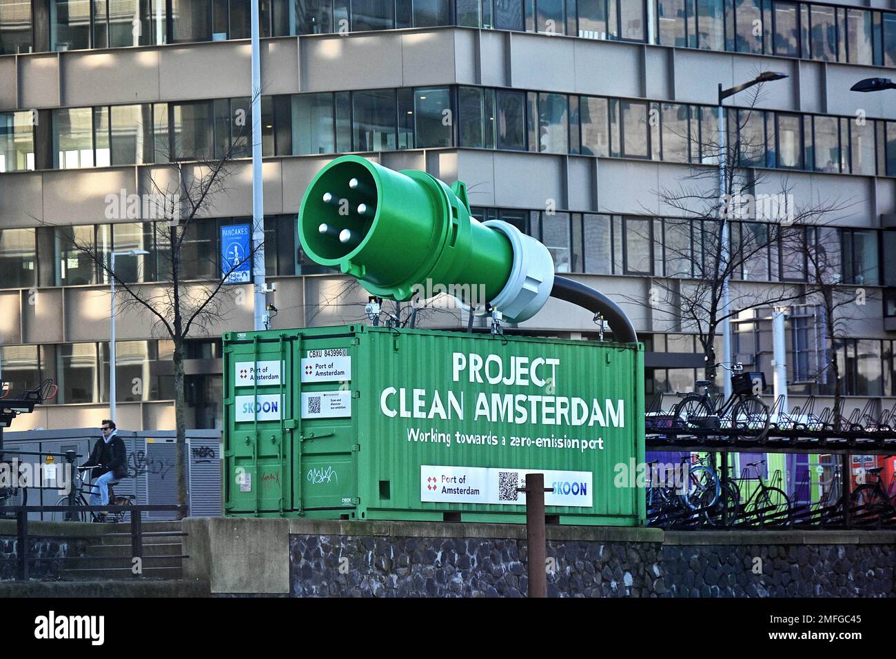 Paesi Bassi, Amsterdam: Installazione pubblicitaria per il “Project Clean Amsterdam”, che rappresenta una spina verde gigante su un contenitore. Questo ini Foto Stock