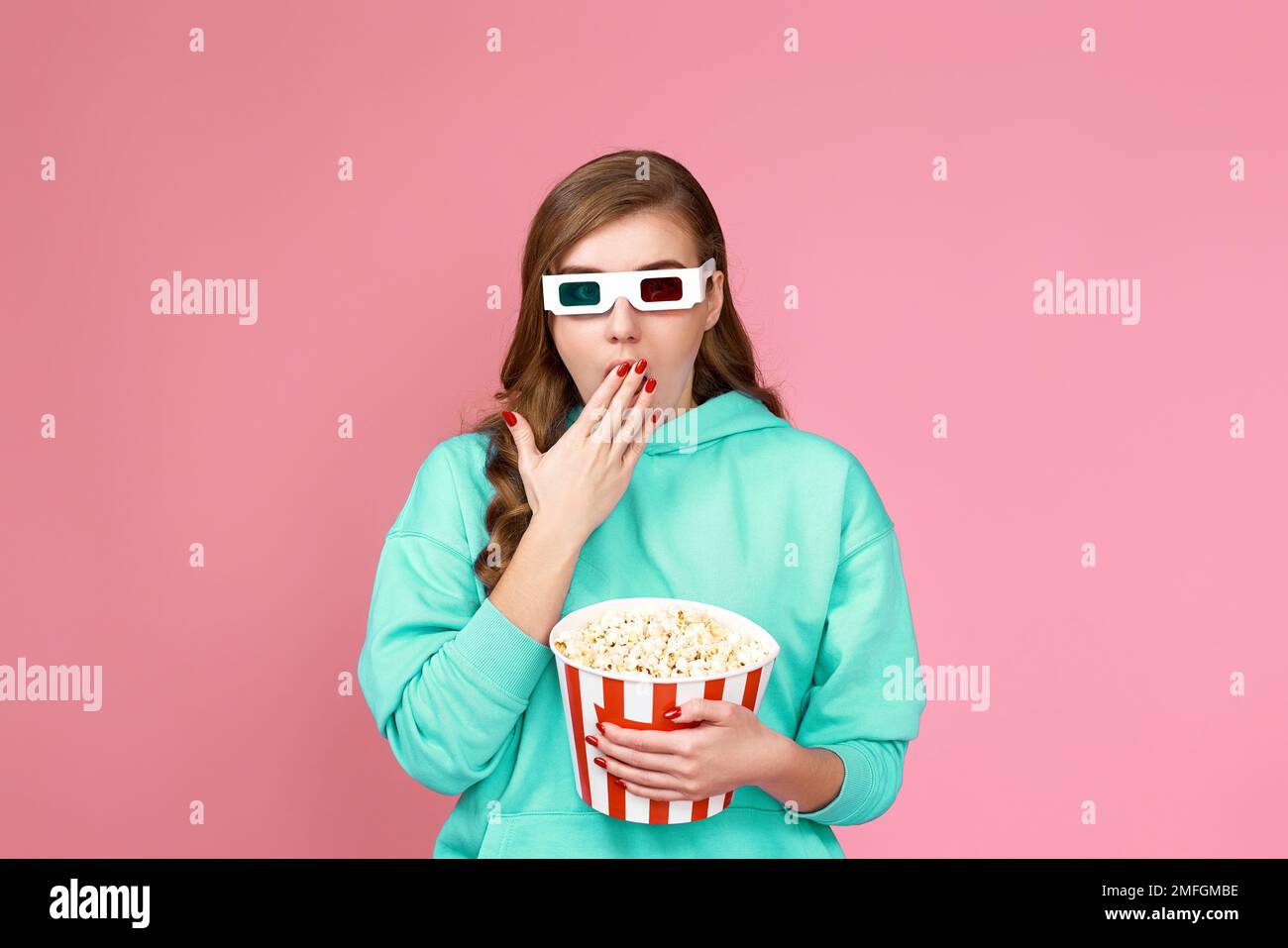donna in felpa con secchio di popcorn Foto Stock