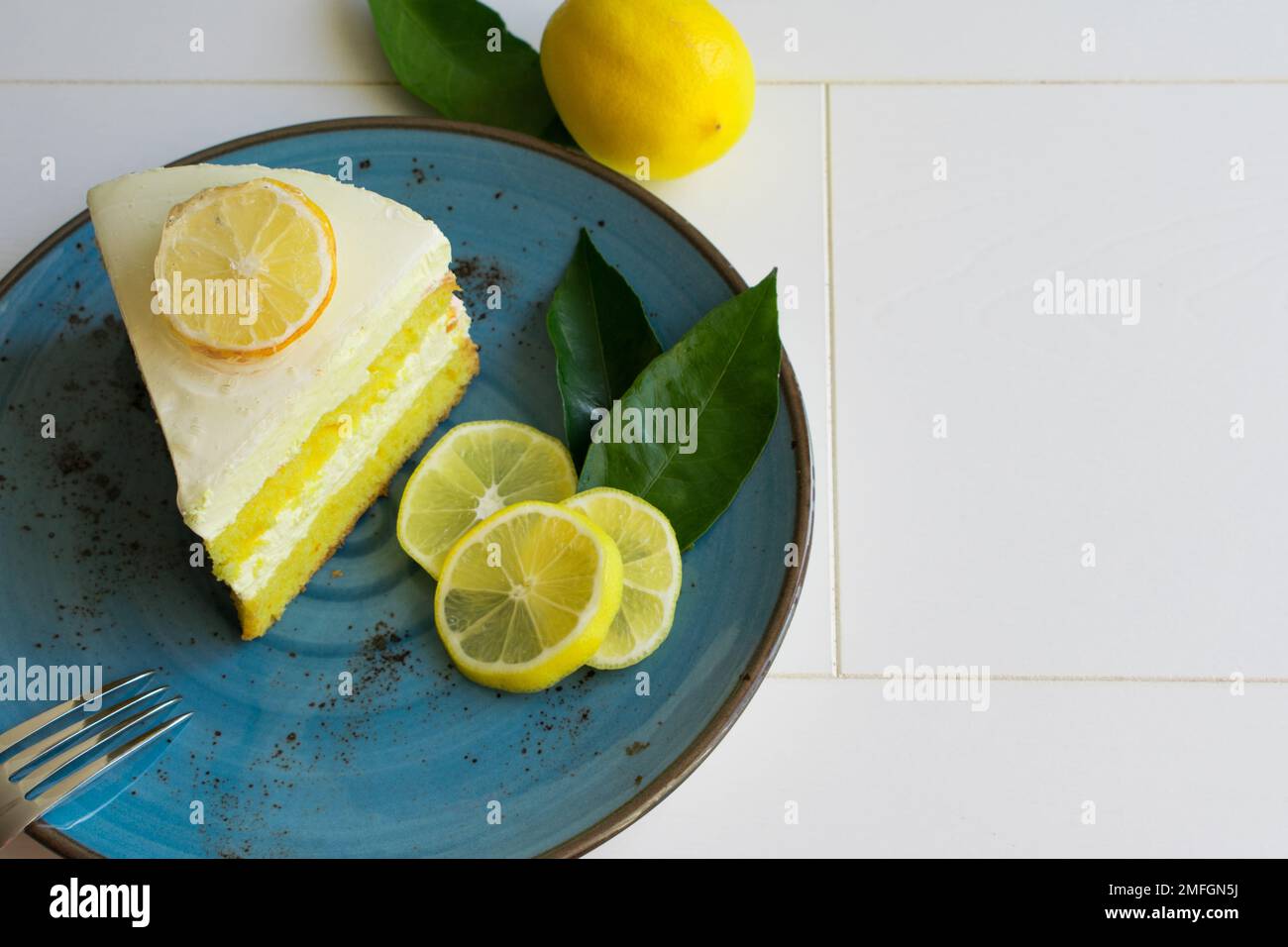 Un pezzo di torta di crema al limone su un piatto, presentazione di deliziose fette di torta ​​lemon, vista dall'alto. Foto Stock