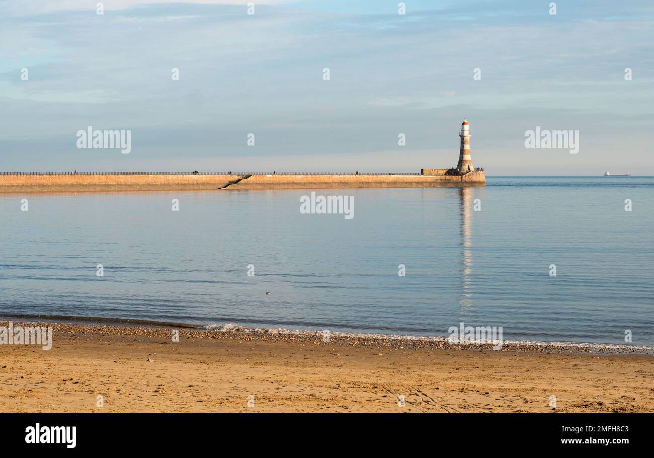 Meteo UK 24-1-2023 Faro di Roker riflesso in un mare liscio, Sunderland, Inghilterra, Regno Unito Foto Stock