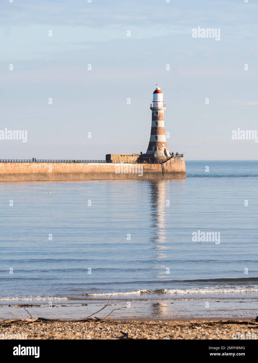 Meteo UK 24-1-2023 Faro di Roker riflesso in un mare liscio, Sunderland, Inghilterra, Regno Unito Foto Stock