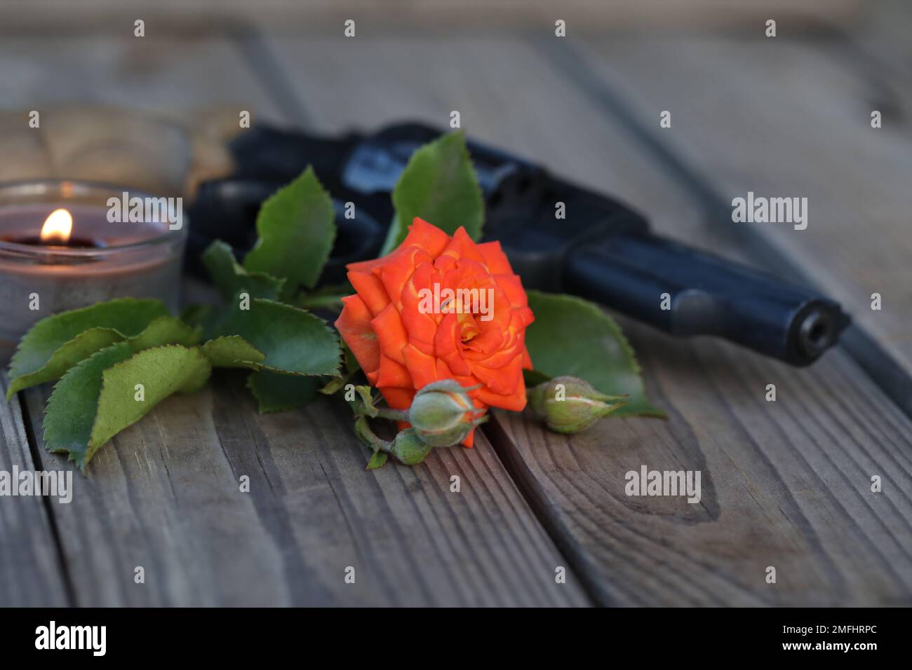 foto d'arte. vintage still life con pistola e rosa su sfondo di legno Foto Stock