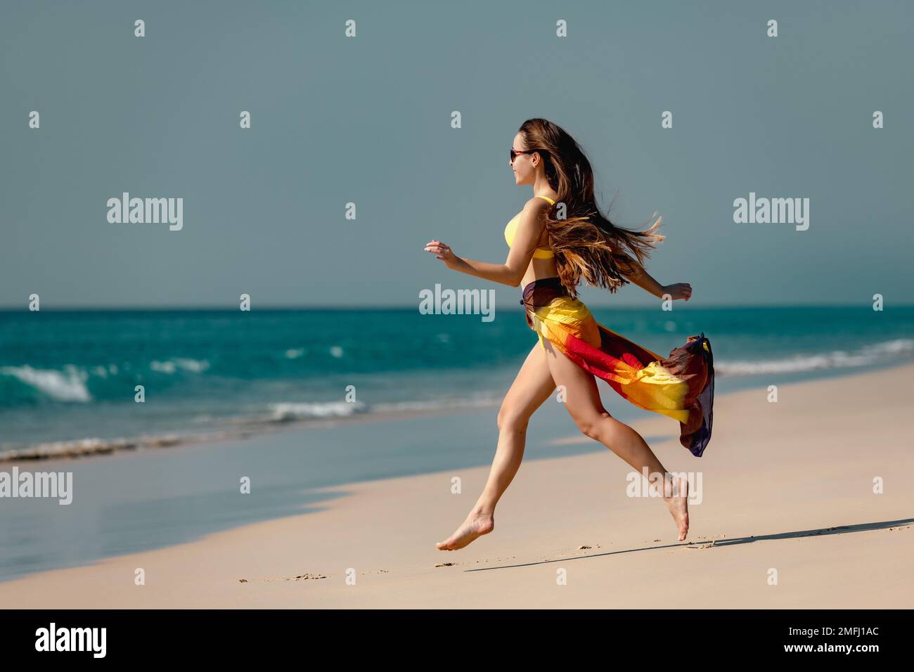 Bella giovane ragazza felice corre in bikini alla spiaggia di sabbia bianca. Concetto di vacanza tropicale Foto Stock