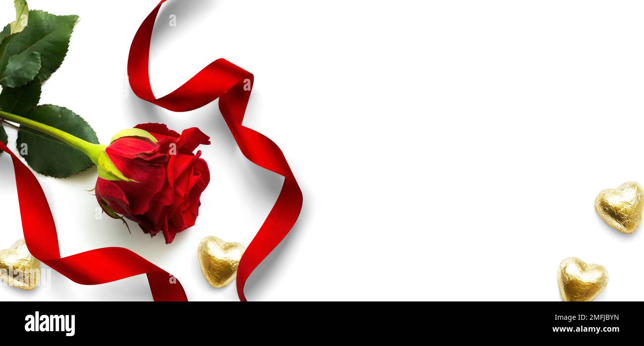 Elementi di design per banner per San Valentino sfondo. Fiore di rosa rosso, caramelle dorate a forma di cuore e nastro rosso su sfondo bianco, piatto Foto Stock