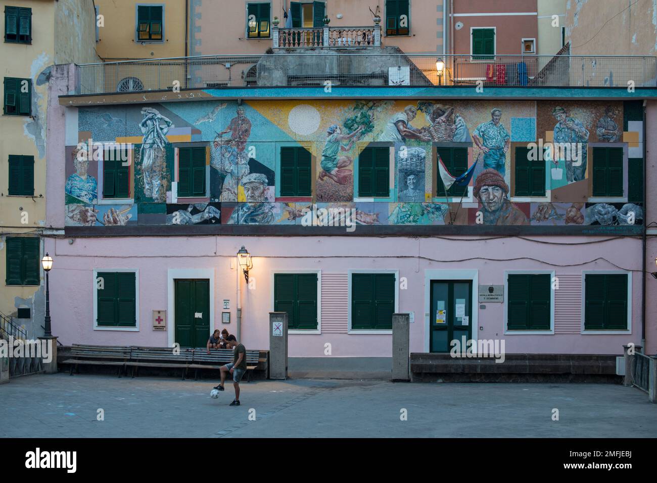 Edificio dipinto e ragazzo che gioca a calcio, cinque Terre Foto Stock