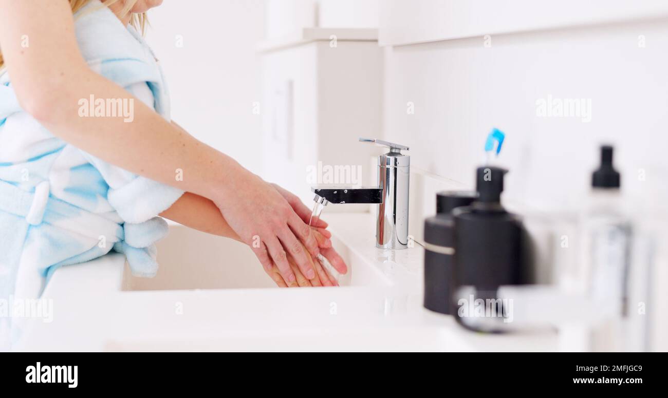 Pulizia, madre e bambino lavano le mani nel bagno della loro casa per la salute insieme. Ragazza che impara a pulire le mani con l'aiuto di mamma, acqua Foto Stock