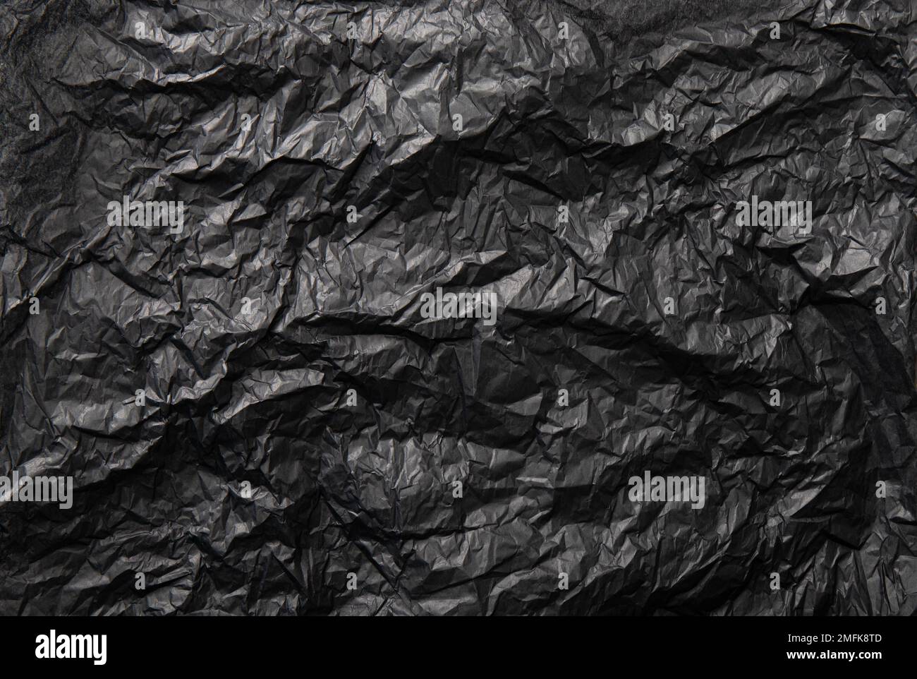 Vista piatta di colore nero grattato confezione di riempimento carta di seta, prodotti di pubblicità sfondo, luce studio e ripresa. Molto spazio di copia. Foto Stock