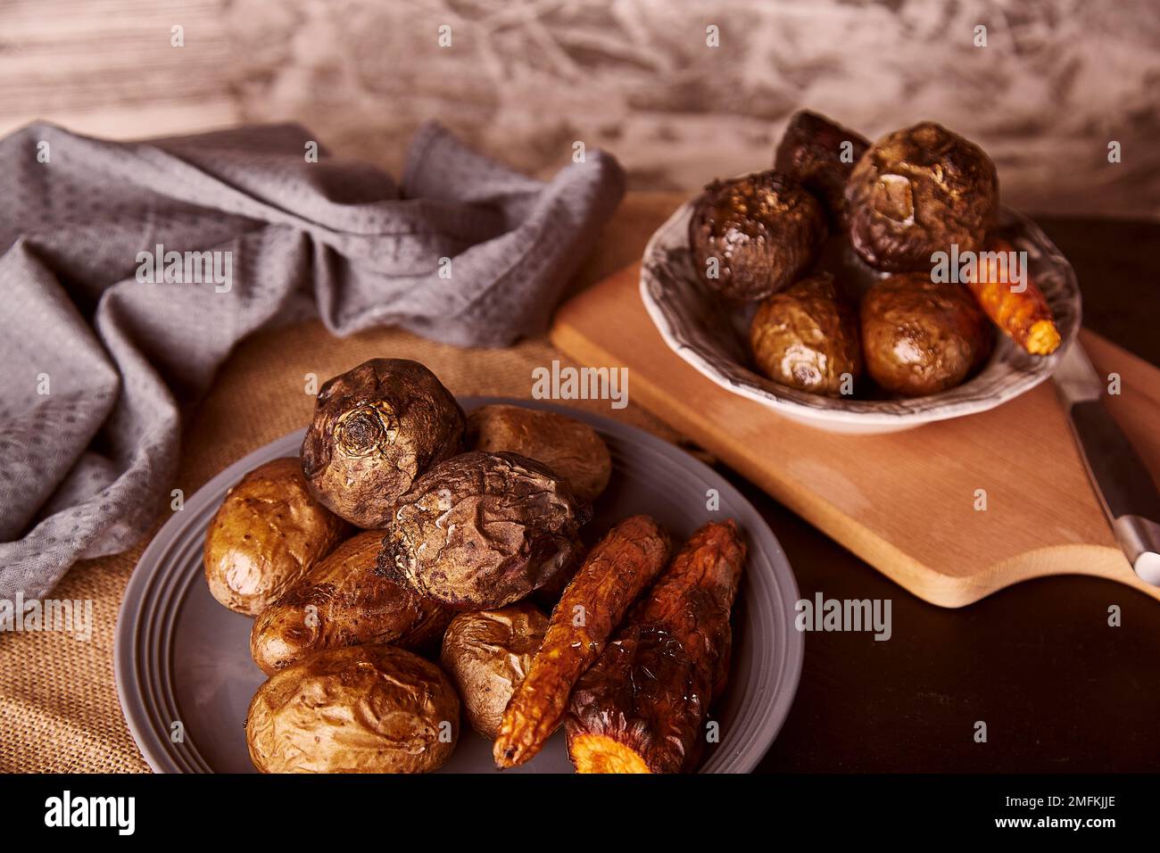 Verdure sane al forno su sfondo rustico - carote, patate, barbabietole. Dieta alimentare intera, dieta mediterranea Foto Stock