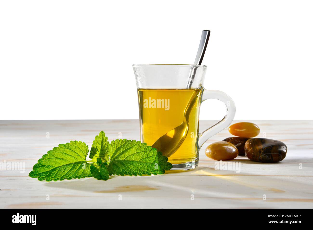 Tè alle erbe al limone in una tazza di vetro con balsamo al limone Foto Stock