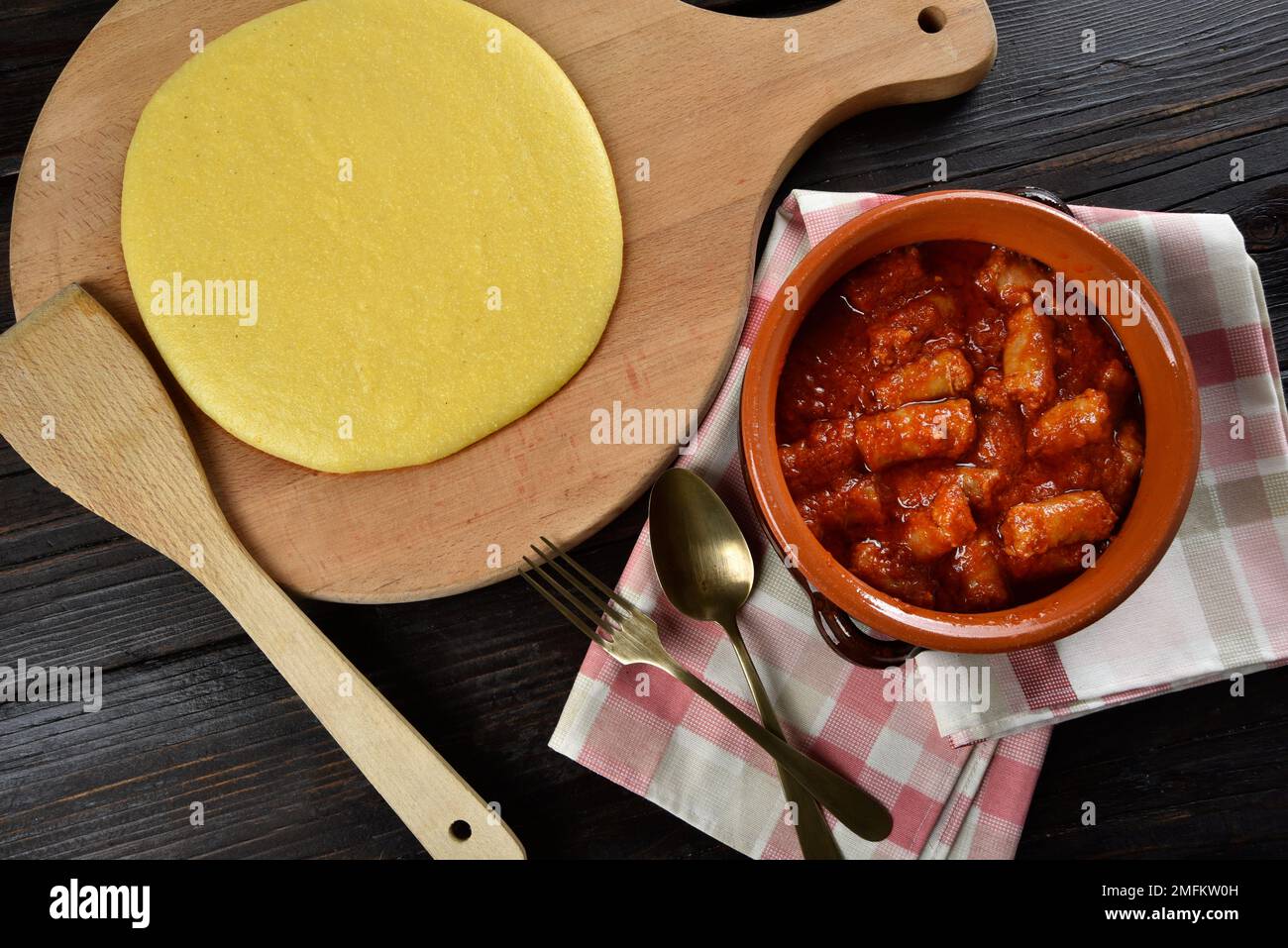Piatto con polenta e sugo di salsiccia su un tavolo di legno Foto Stock