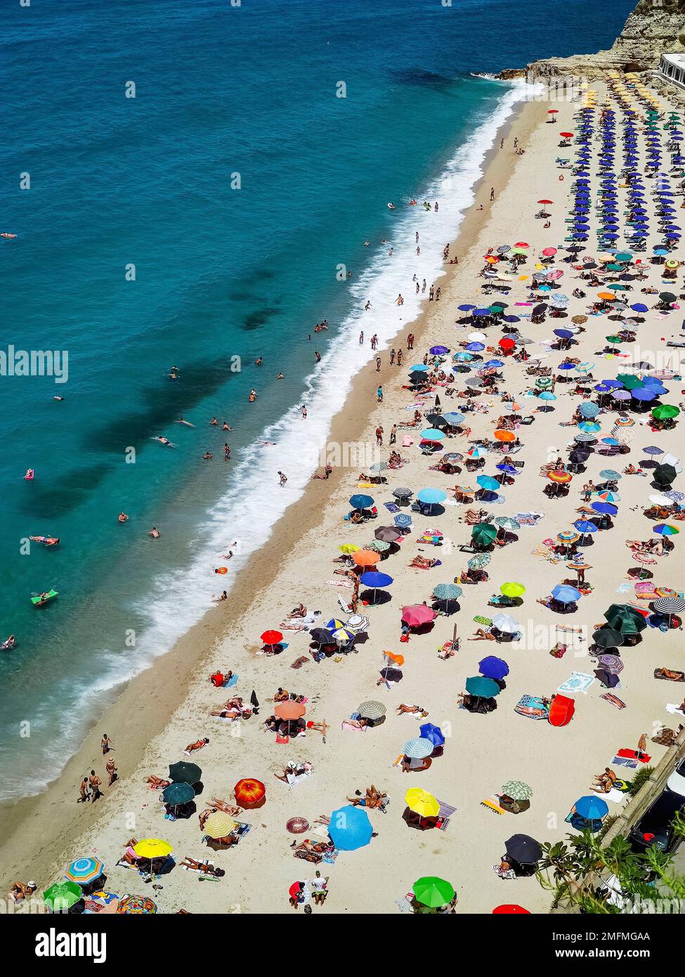 Spiagge italiane della Calabria visto dall'alto, i turisti visti riposare sotto ombrelloni colorati Foto Stock