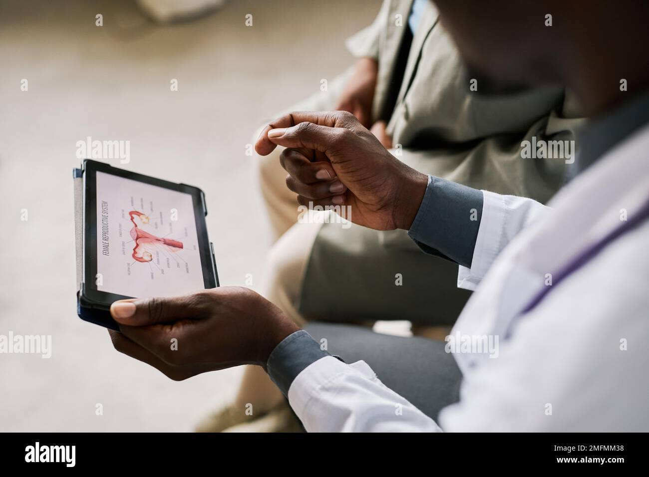 Primo piano del medico che tiene la compressa con le tabelle degli organi riproduttivi femminili, spazio di copia Foto Stock