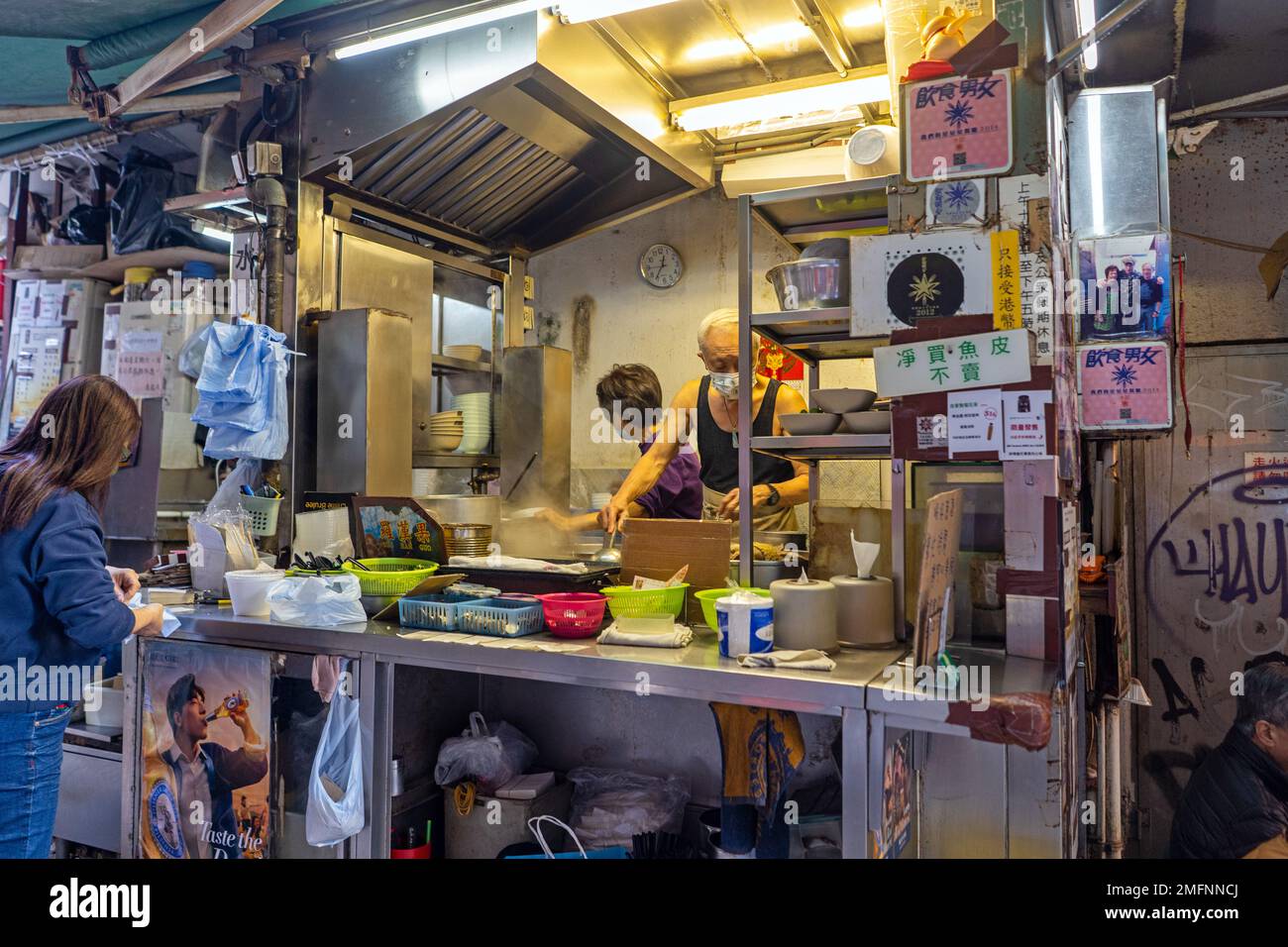 Hong Kong - 2022 dicembre - Stall Man cucina cibo dai Pai Dong Foto Stock