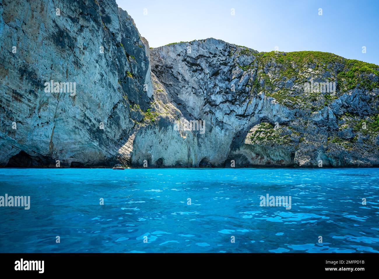 Fantastica vista del magnifico gioco di colori al largo della costa di Zante con le sue acque cristalline turchesi e le alte scogliere che si innalzano dal mare Foto Stock