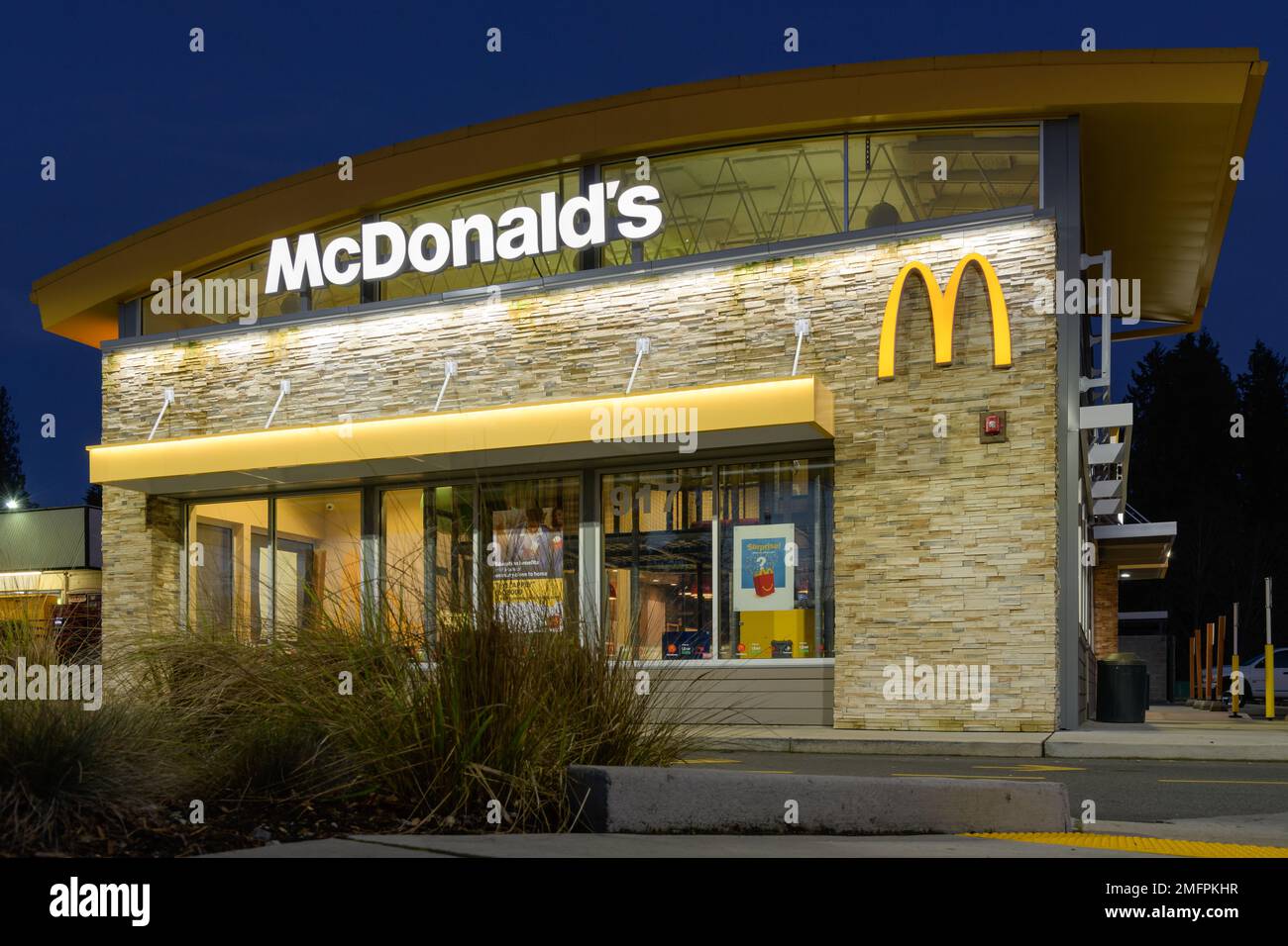 Snohomish, WA, USA - 23 gennaio 2023; facciata del ristorante McDonald's di notte con insegna e logo illuminati Foto Stock