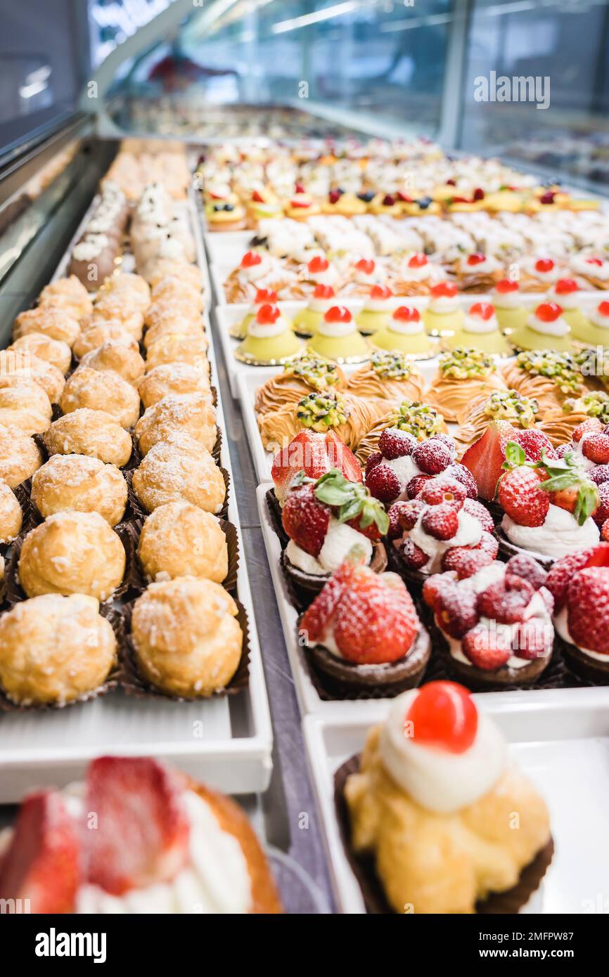 Panetteria italiana, finestra di dessert in una pasticceria. Prodotti freschi e gustosi Foto Stock