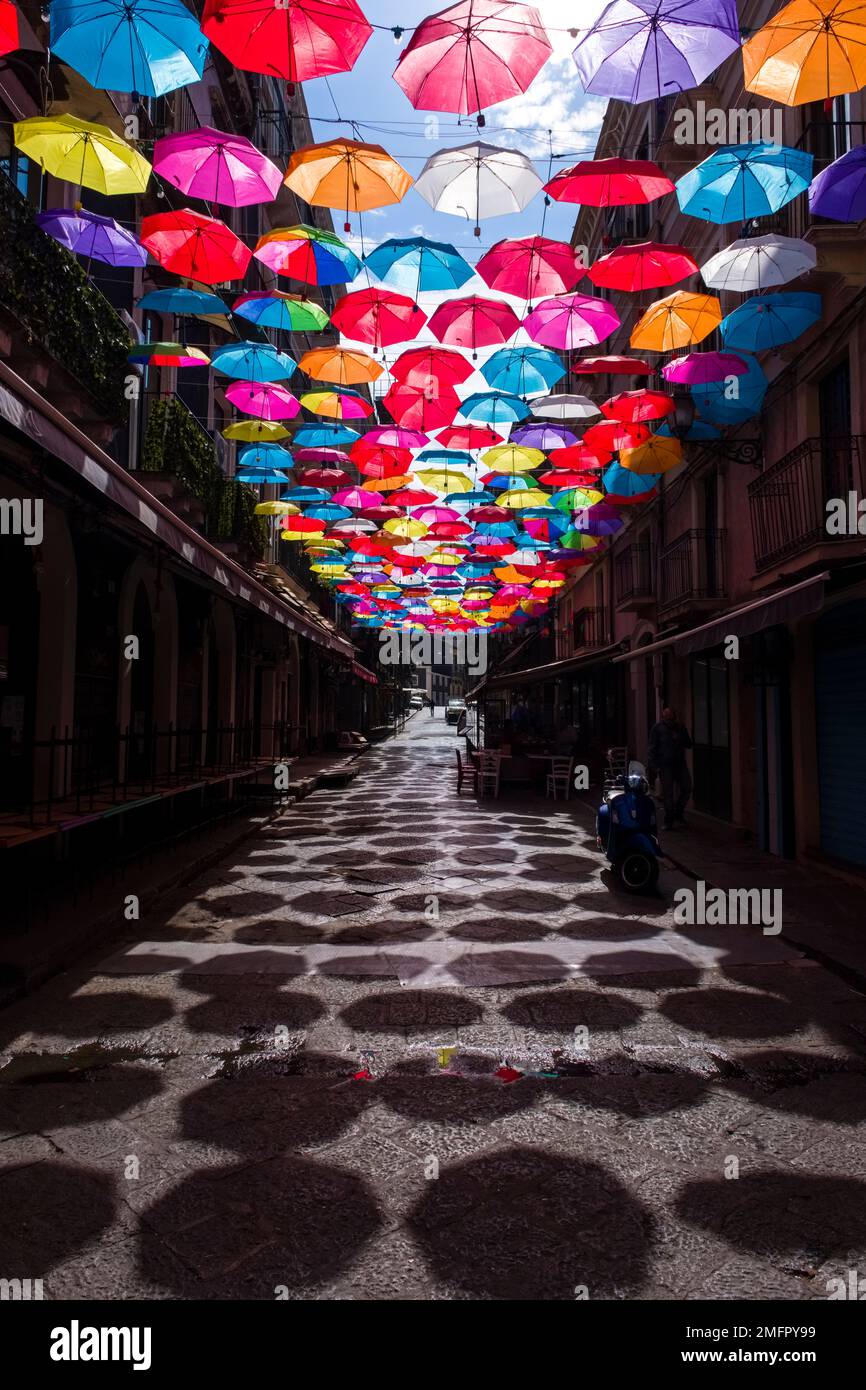 Ombrelloni colorati appendono decorativamente in uno dei vicoli del centro storico di Catania. Foto Stock