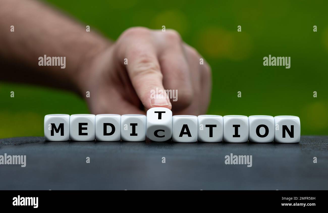 Simbolo per fare meditazione invece di prendere farmaci. La mano gira i dadi e cambia la parola farmaco in meditazione. Foto Stock