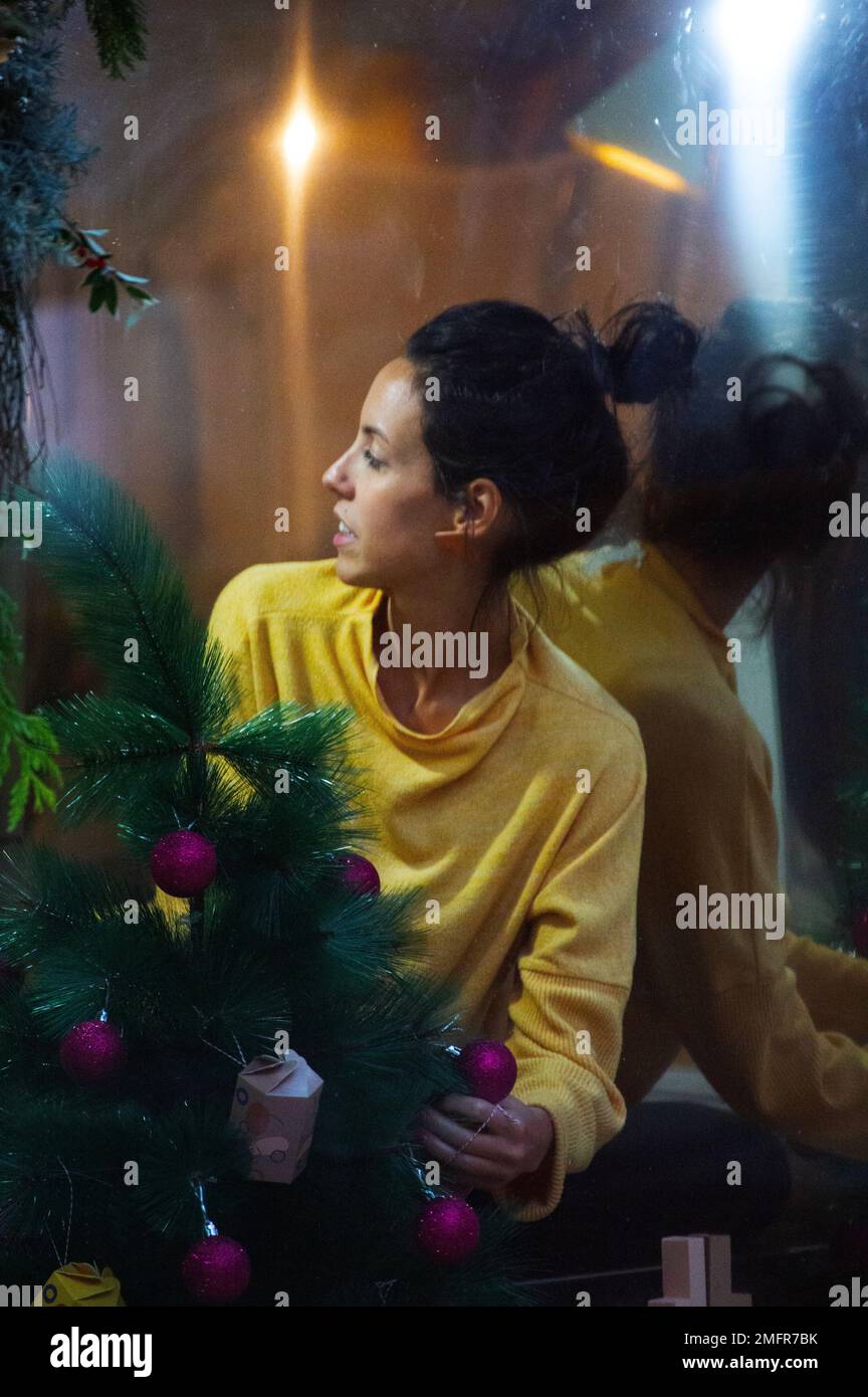 Donna che organizza la vetrina del negozio a Natale Foto Stock