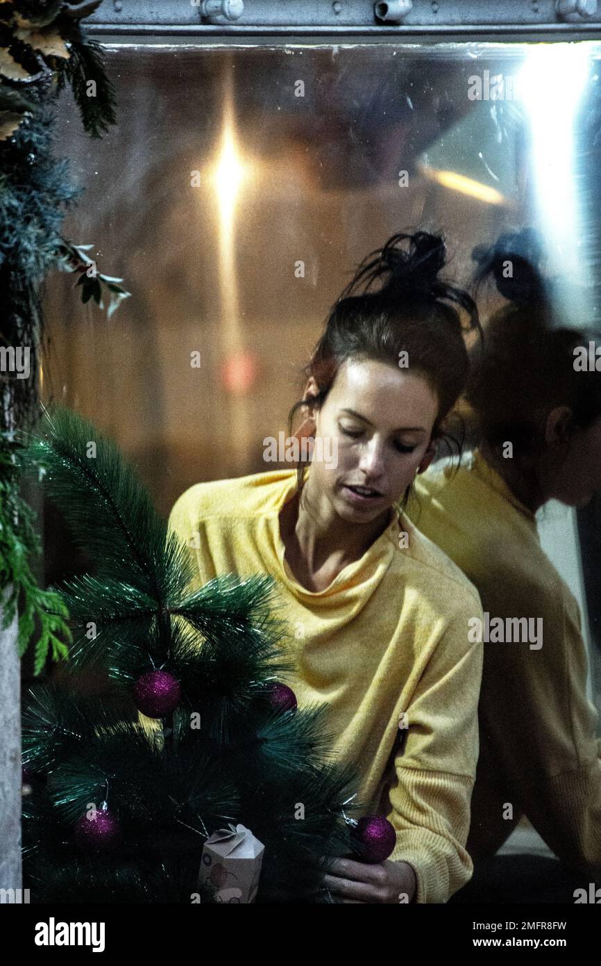 Donna che organizza la vetrina del negozio a Natale Foto Stock