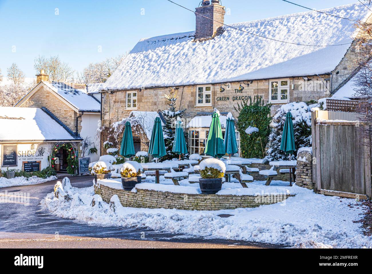 Neve d'inverno al Green Dragon Inn Pub & Shop nel villaggio Cotswold di Cockleford vicino a Cowley, Gloucestershire, Inghilterra UK Foto Stock
