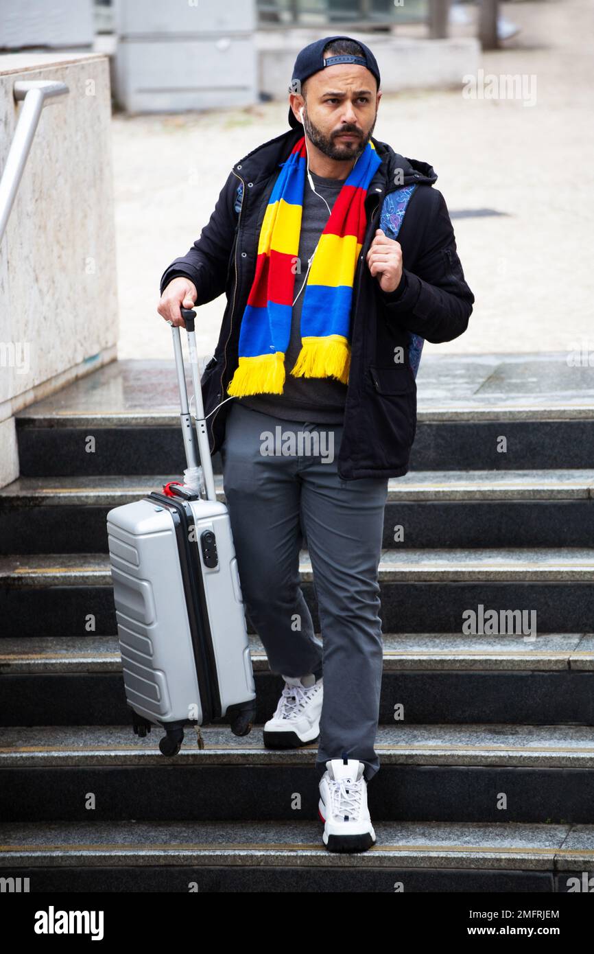 Un uomo con valigia scende le scale Foto Stock