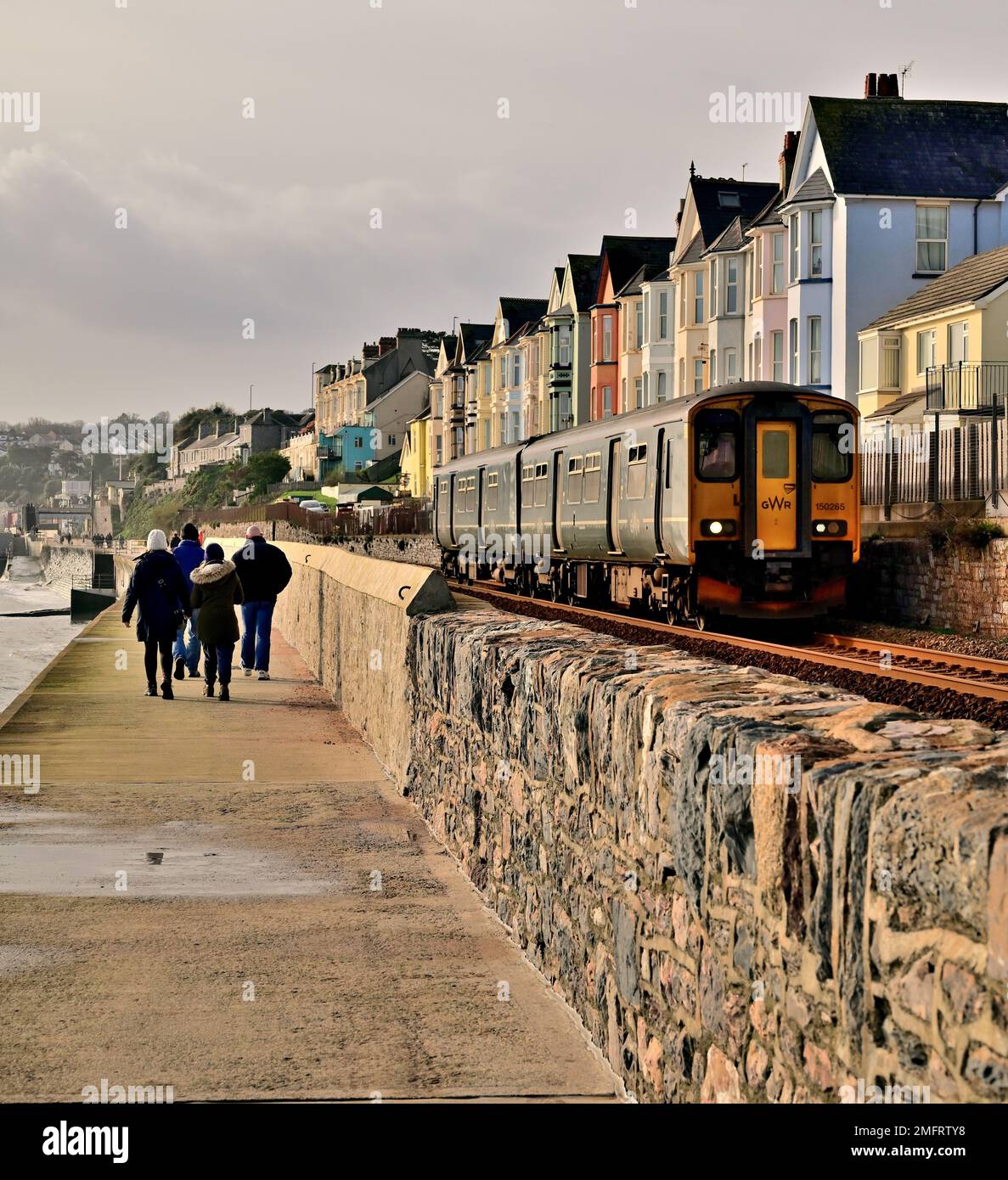 Un treno locale che passa per la nuova sezione del muro di mare a Dawlish che è stato lavato via durante la Grande tempesta del febbraio 2014. Foto Stock