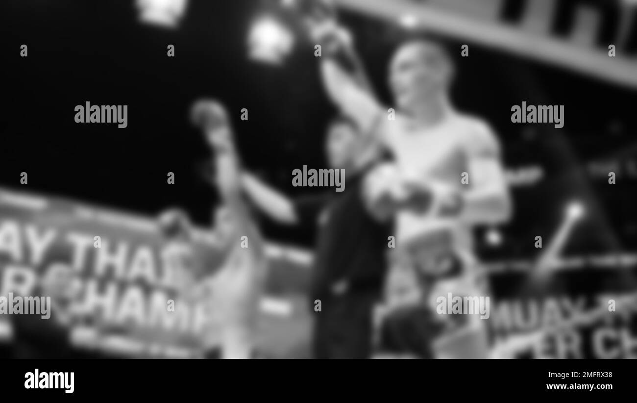 Immagini sfocate in bianco e nero stile fotografico di boxe thailandese o Muay thailandese o Kickboxing che locale e pugile Foriegn stanno combattendo sul ring al coperto Foto Stock