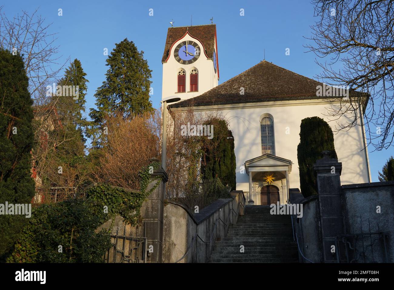 Chiesa protestante a Hinwil, Svizzera catturata di fronte a basso angolo vista con la sua torre dell'orologio. Foto Stock