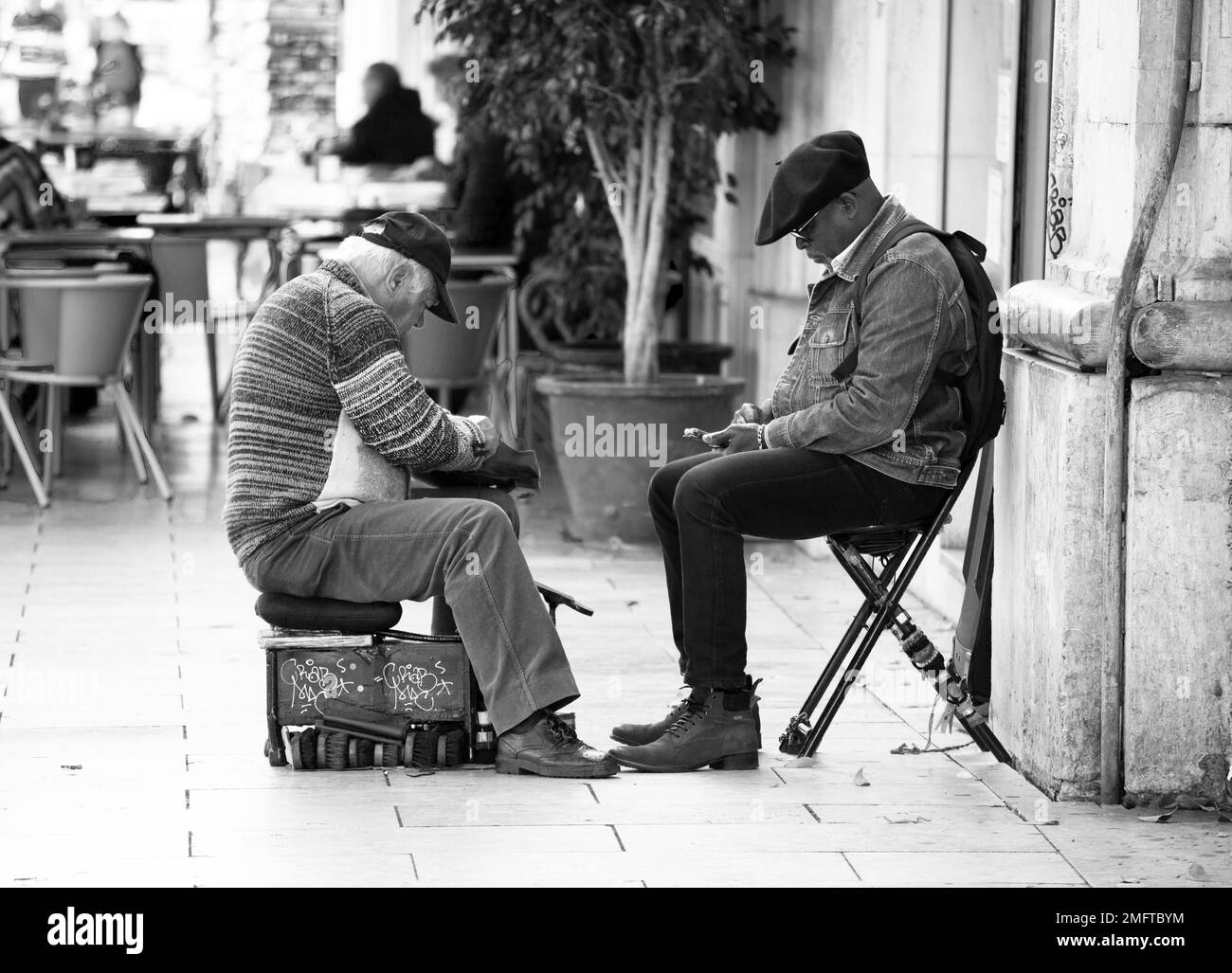 L'uomo anziano pulisce le scarpe per le strade Foto Stock